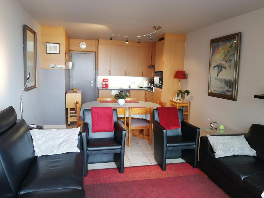 sala de estar con mesa y sillas y cocina en De Strandwandeling 0203 Appartement met frontaal zeezicht, en Ostende