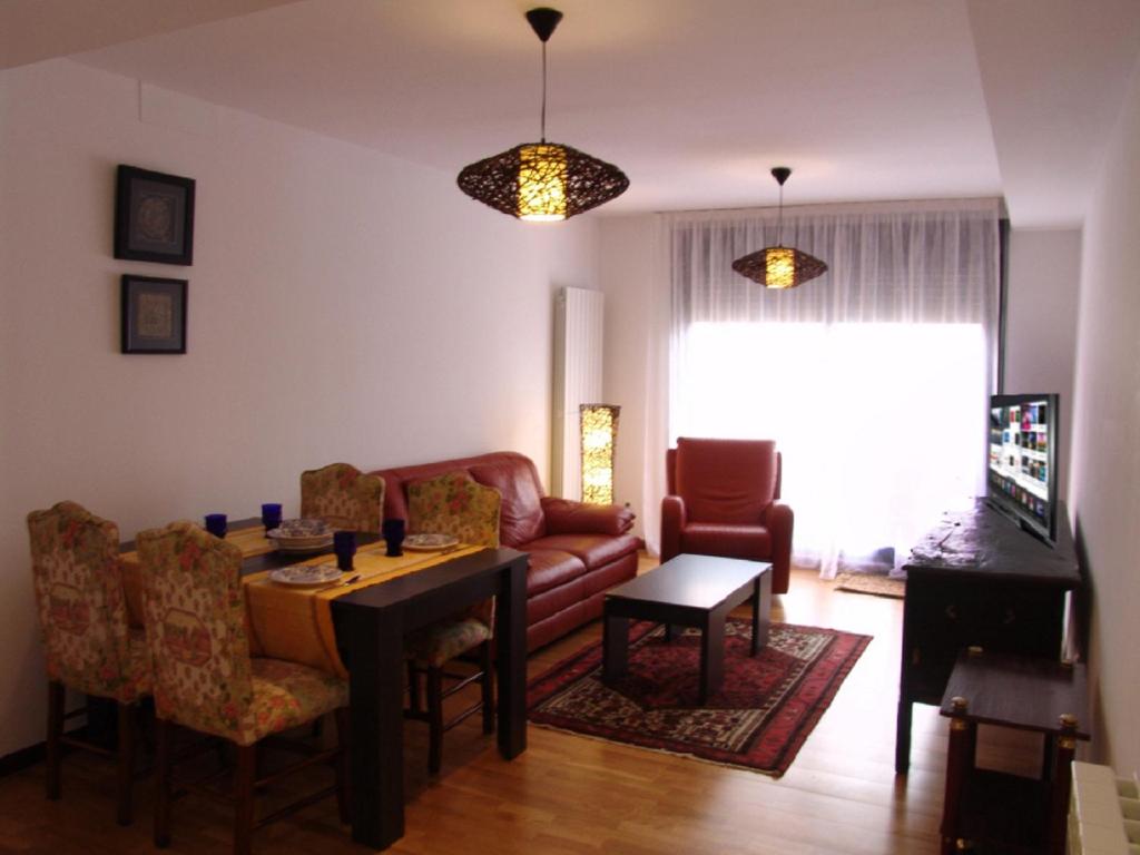 a living room with a table and a couch at Apartamento Golf Rioja Alta in Cirueña