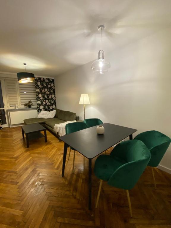 uma sala de estar com uma mesa e cadeiras verdes em Tabago Studio 10 em Opole