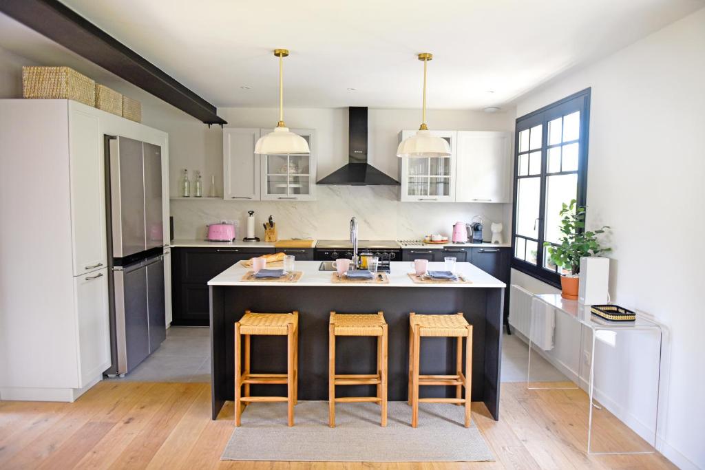 una cocina con una isla grande con 2 taburetes en NEW Remodeled Home 4Bed/3.5Bath, Walking to BEACH!, en Saint-Lunaire