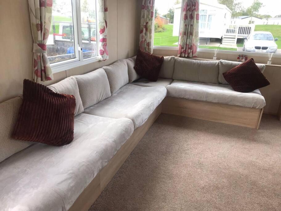 a white couch in a living room with windows at The fairways in Lincoln