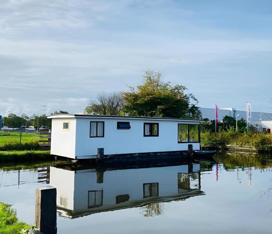 a house on a boat in the water at Woonboot in Sumar gelegen tussen Leeuwarden en Drachten in Suameer