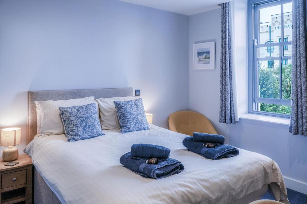 a bedroom with a bed with blue pillows on it at Ocean Cabins No 4 At The Square - Saundersfoot in Saundersfoot