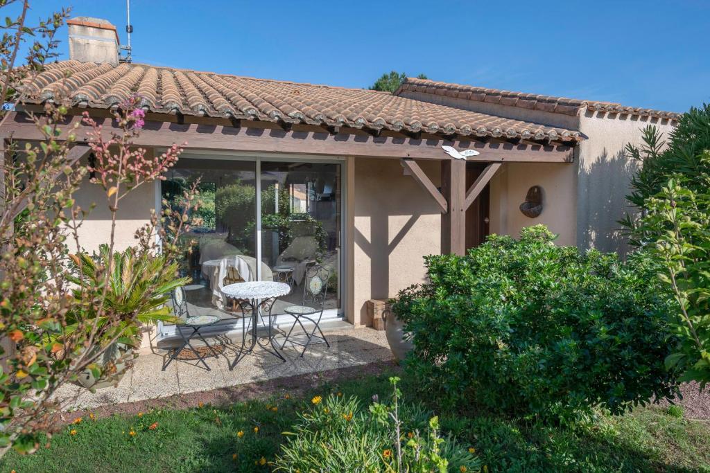 a patio of a house with a table and chairs at Préfailles - Maison 6 Pers - 200m des plages in Préfailles