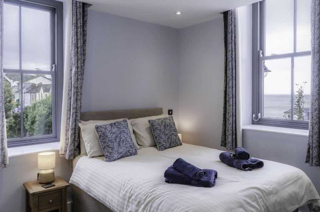 a bedroom with a bed with two blue towels on it at Ocean Cabins No 6 At The Square - Saundersfoot in Saundersfoot