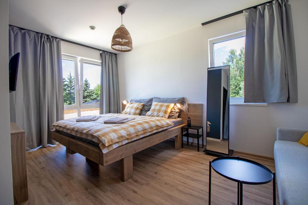 um quarto com uma cama e um sofá em Penzion Racek em Tuchlovice