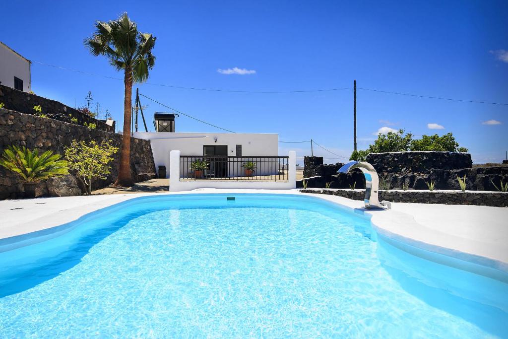een groot zwembad in een tuin met een huis bij Peñas Blancas in Mácher