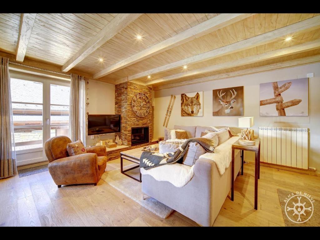 Una gran sala de estar con un sofá y un televisor. en SANGLIER de Alma de Nieve, en Naut Aran (Alto Arán)