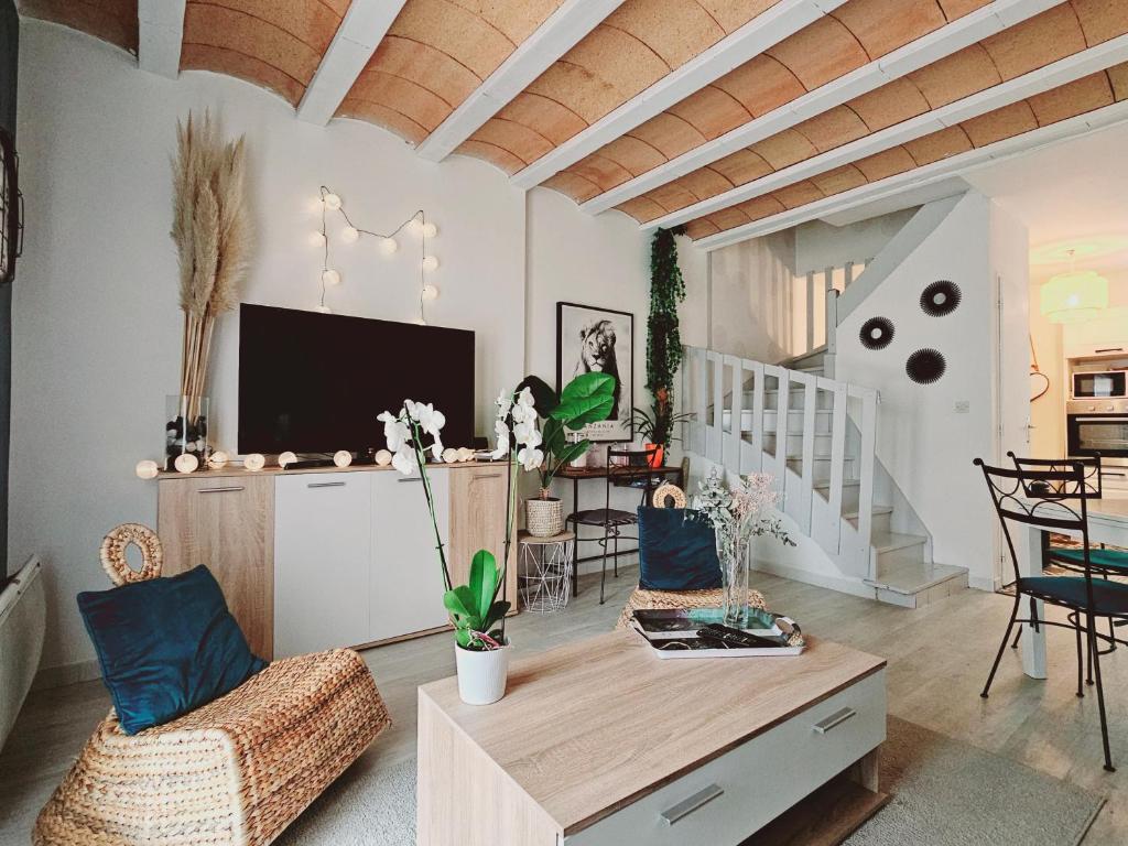 un salon avec une télévision, une table et des chaises dans l'établissement Maison chaleureuse à Uzès, à Uzès