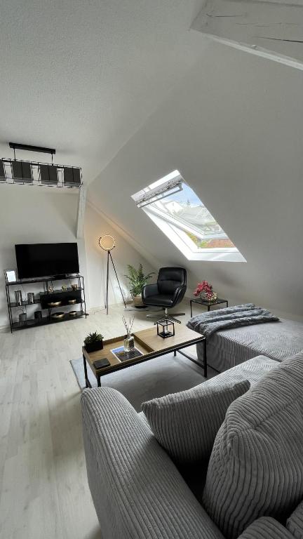 uma sala de estar com um sofá e uma clarabóia em K-Business-Apartments em Oberesslingen
