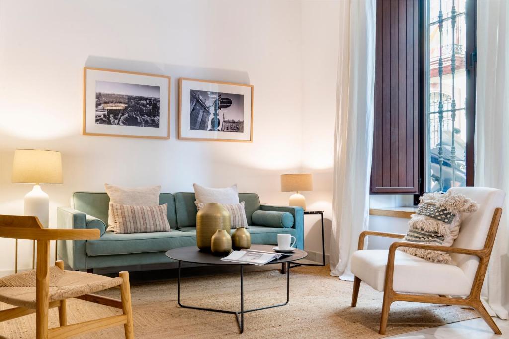 sala de estar con sofá verde y mesa en MonKeys Apartments Luxury Puerta de la Maestranza en Sevilla
