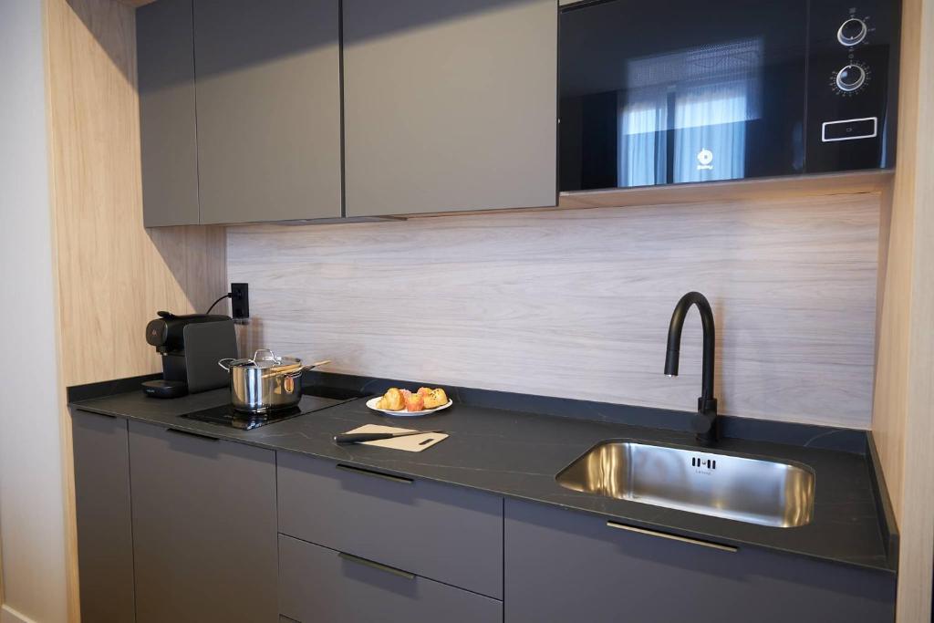 cocina con fregadero y encimera en Hotel-Apartamentos Primus Suites, en Valencia