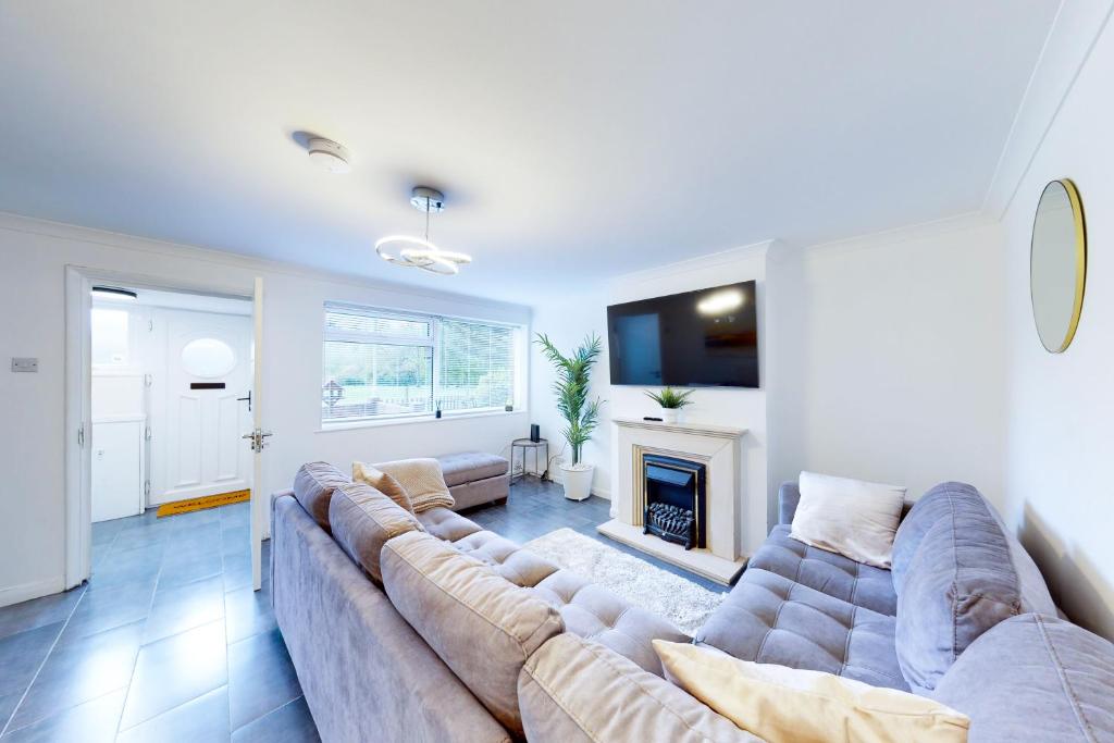 uma sala de estar com um sofá grande e uma lareira em Stunning Ranworth House Sleeps 5 em Bedford