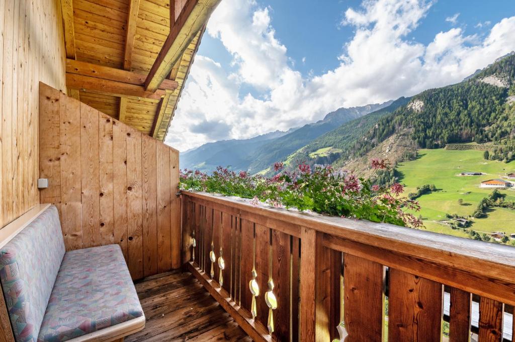 a balcony with a bench and a view of mountains at Glocklechnhof Sonnenschein in Cadipietra