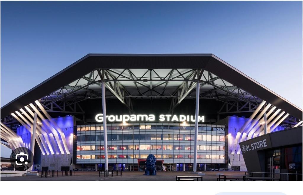 un gran edificio con un cartel en el costado en Groupama stadium, en Décines-Charpieu