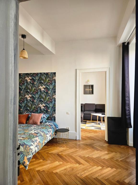 ein Wohnzimmer mit einem Bett und einem Sofa in der Unterkunft Cœur de ville in Bourgoin