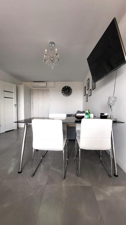 Televízia a/alebo spoločenská miestnosť v ubytovaní Apartamenty Czerwona Stodoła