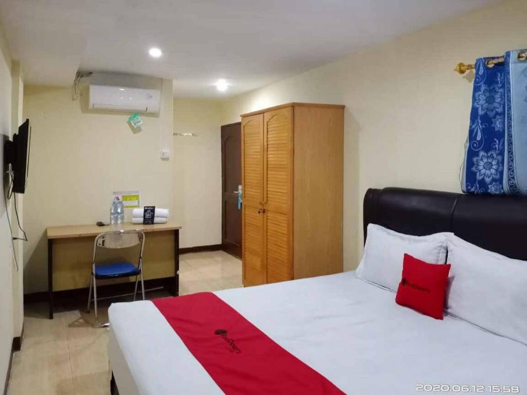 a hotel room with a bed and a desk and a room at RedDoorz At Jalan Japaris Medan in Medan