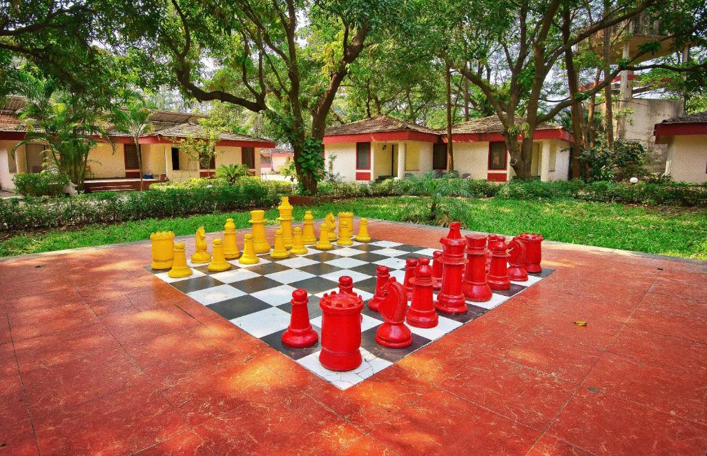 a chess board with red and yellow chess at Srushti Farms Resort in Vasind