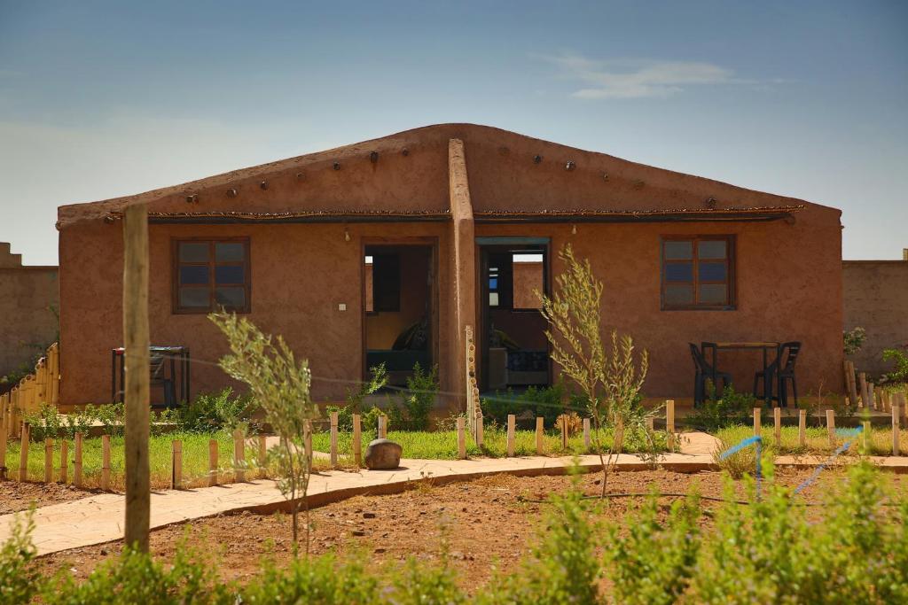 une maison en briques avec un jardin en face de celle-ci dans l'établissement Dar Koujane dôme, à Marrakech