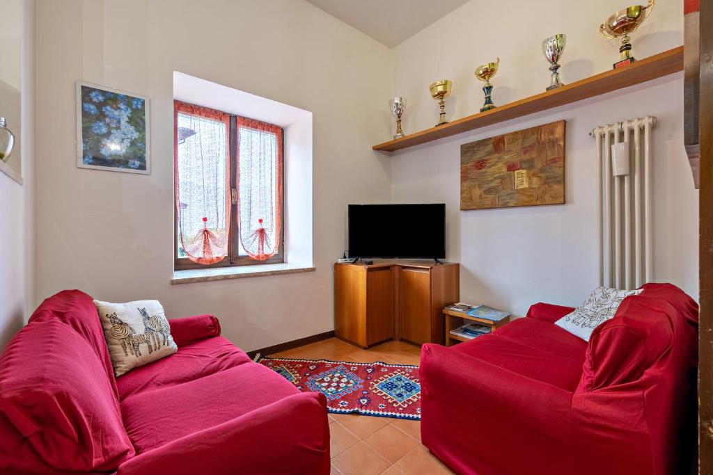 - un salon avec deux canapés rouges et une télévision dans l'établissement Casa Non Ti Scordar di Me, 