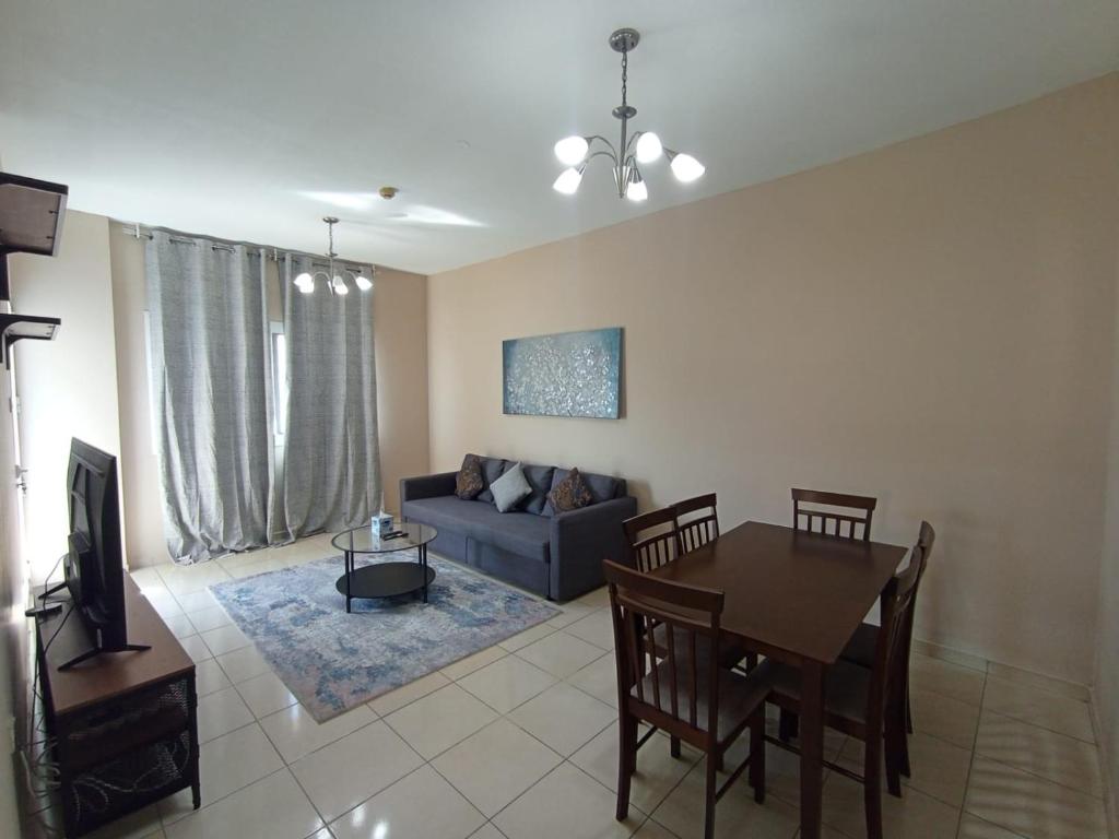 a living room with a couch and a dining room table at Marbella Holiday Homes - Al Nahda 2BHK in Dubai