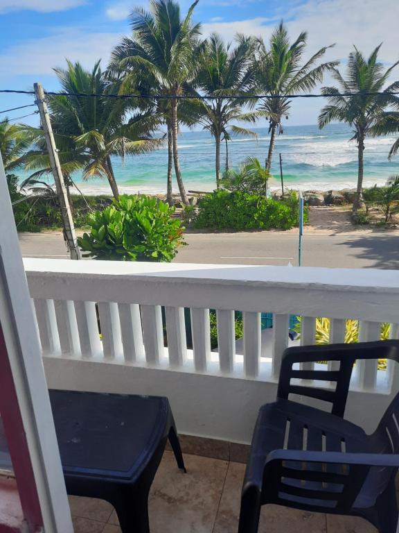 a balcony with a view of the ocean and palm trees at White Surfing Beach Resort in Unawatuna