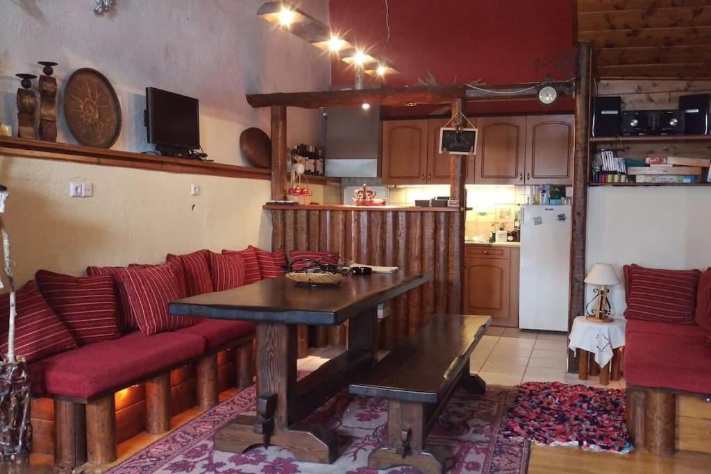 Traditional House in Dimitsana في ديميتسانا: غرفة معيشة مع طاولة وأريكة ومطبخ