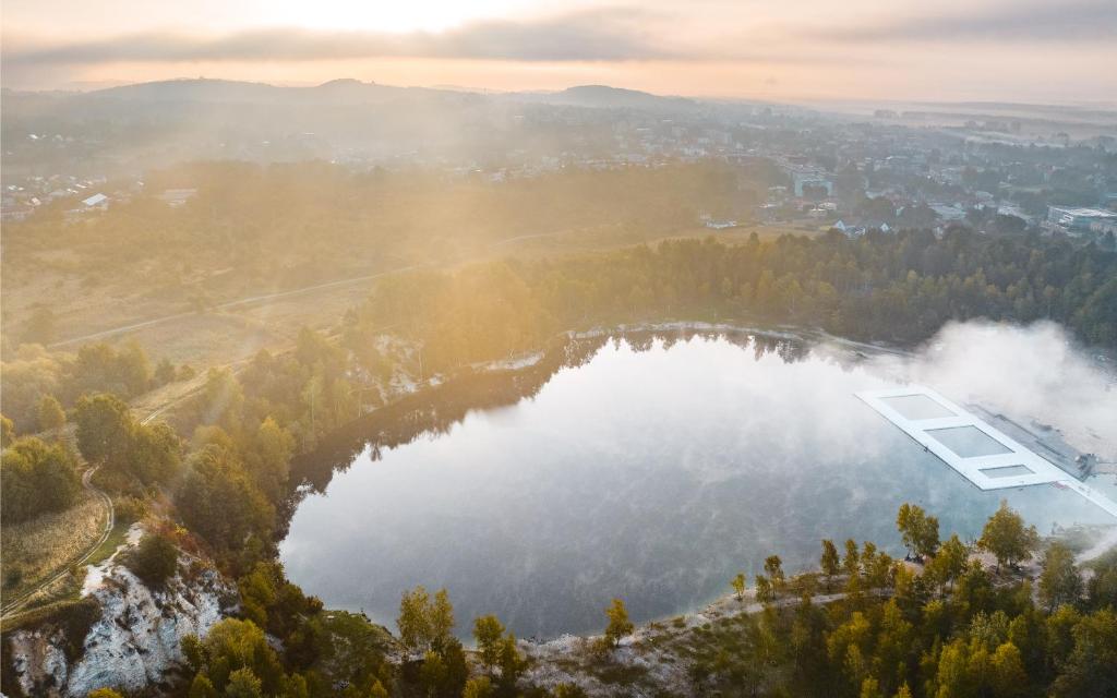 an aerial view of a lake with a building on it at La Playa Resort & Camp Trzebinia in Trzebinia