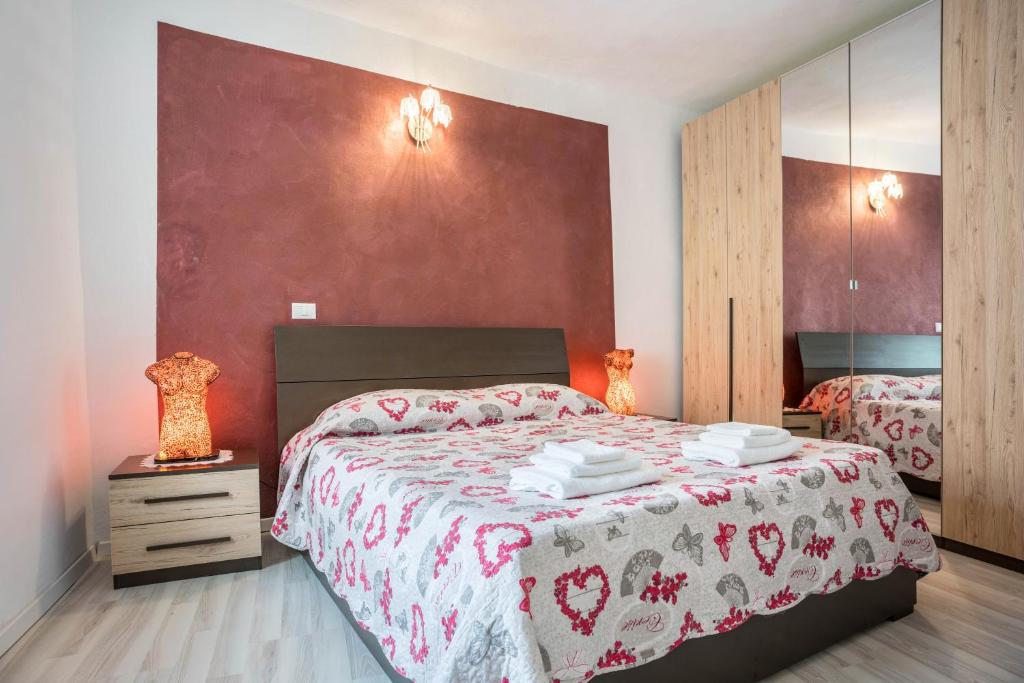 a bedroom with a large bed and a mirror at La vecia casa apartament in Denno