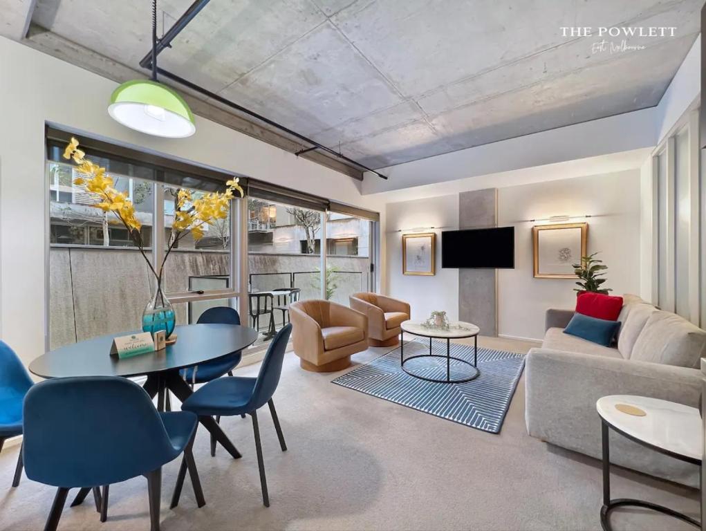 a living room with a couch and a table and chairs at The Powlett - East Melbourne by Ready Set Stay in Melbourne