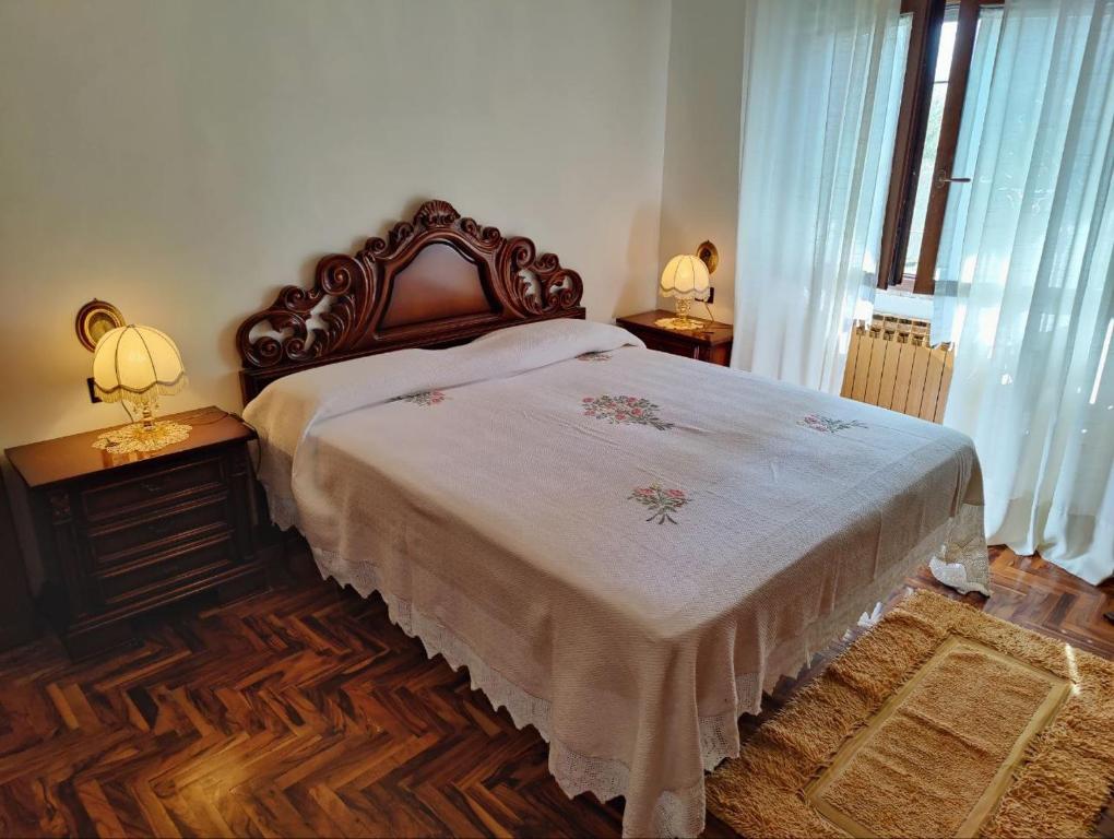 特爾尼的住宿－Villetta del Capriolo con giardino, vicino Centro，一间卧室配有一张床和两张台灯。