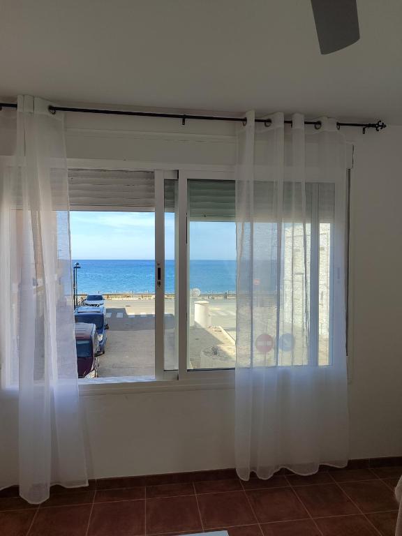 Una habitación con una ventana con vista al mar. en Apartamento El Flamenco Azul Cabo de Gata, en Almería