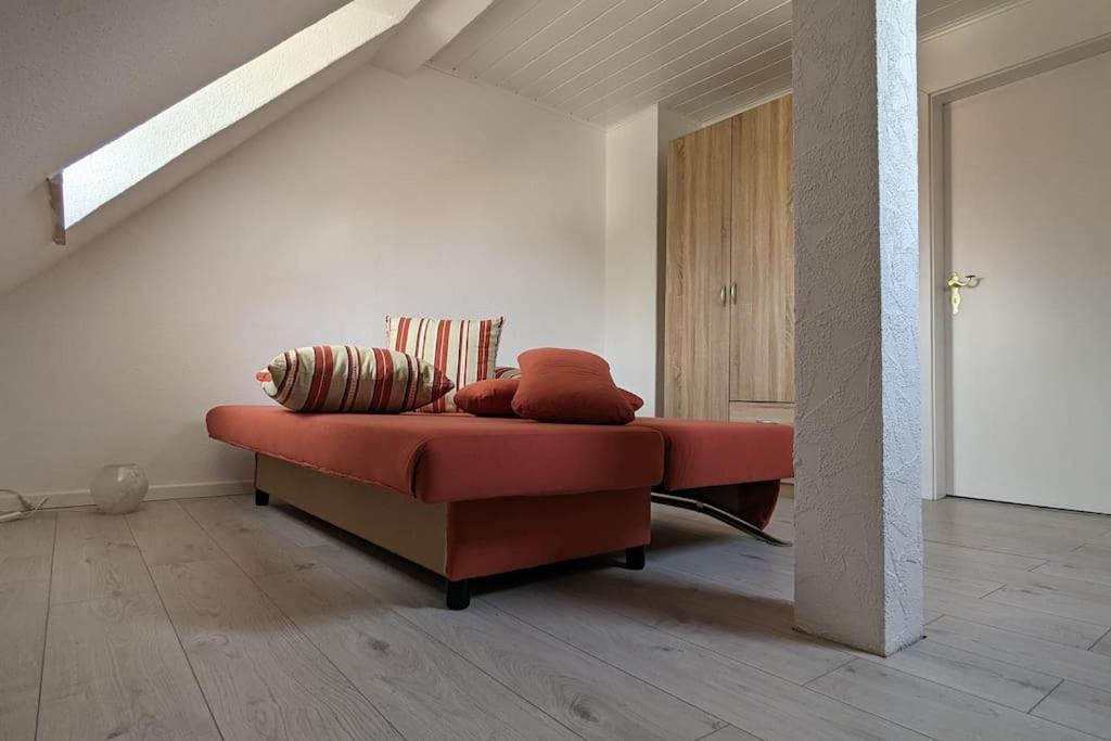 una sala de estar con un sofá rojo con almohadas. en Charmante Dachgeschosswohnung, 