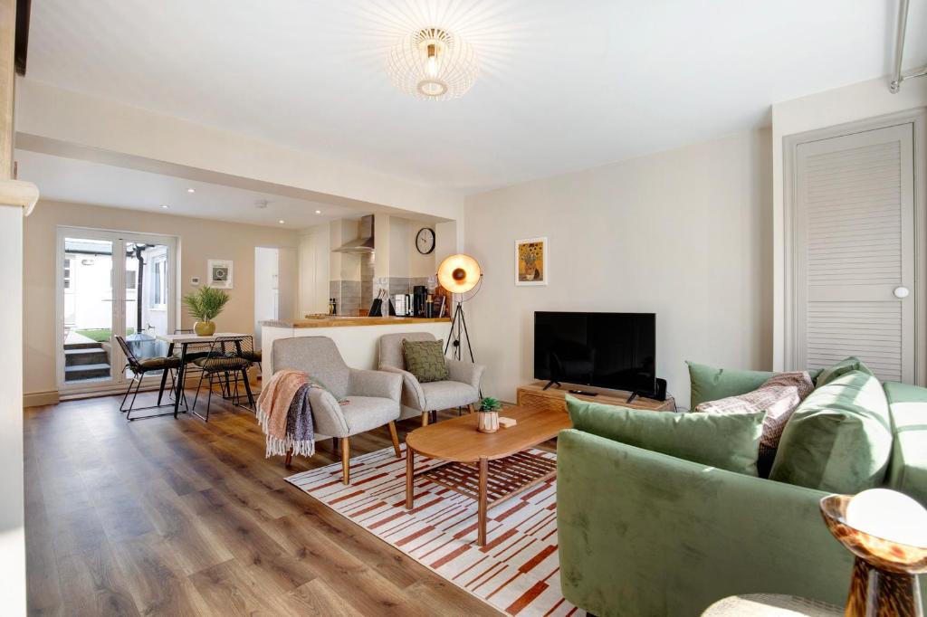 a living room with a couch and a table at Beautifully refurbished cottage in lower Wivenhoe. in Wivenhoe