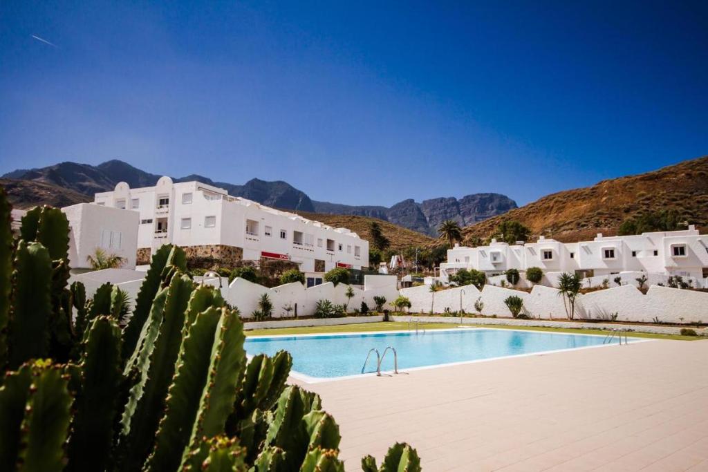 een uitzicht op een resort met een zwembad en een cactus bij Casa Pizquito Agaete con piscina in Agaete
