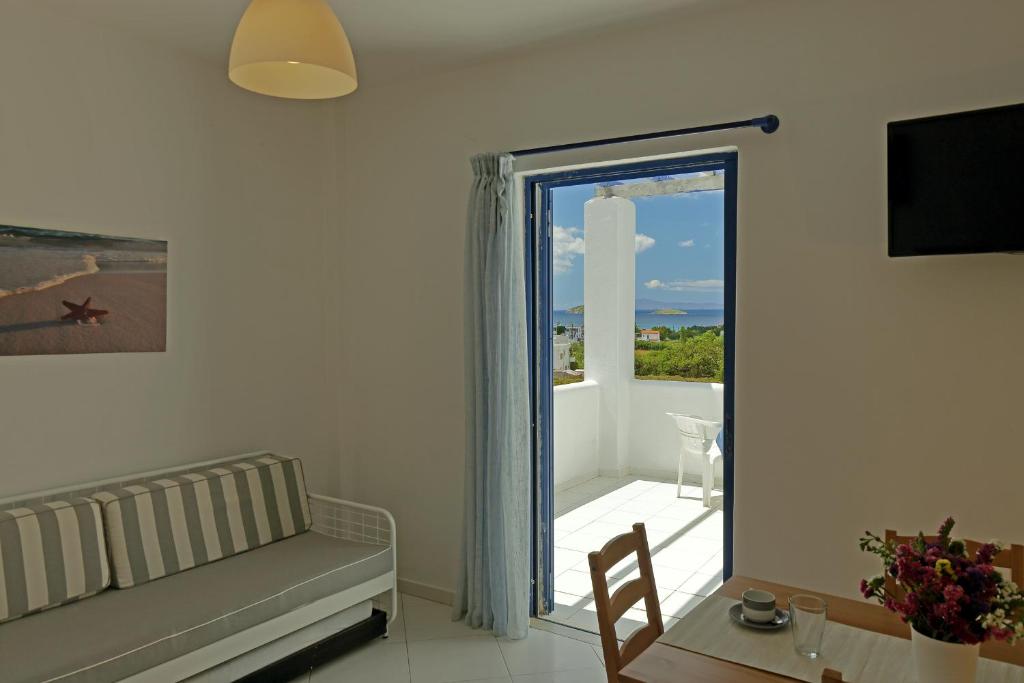 a living room with a couch and a sliding glass door at Spanos Apartments in Agios Petros