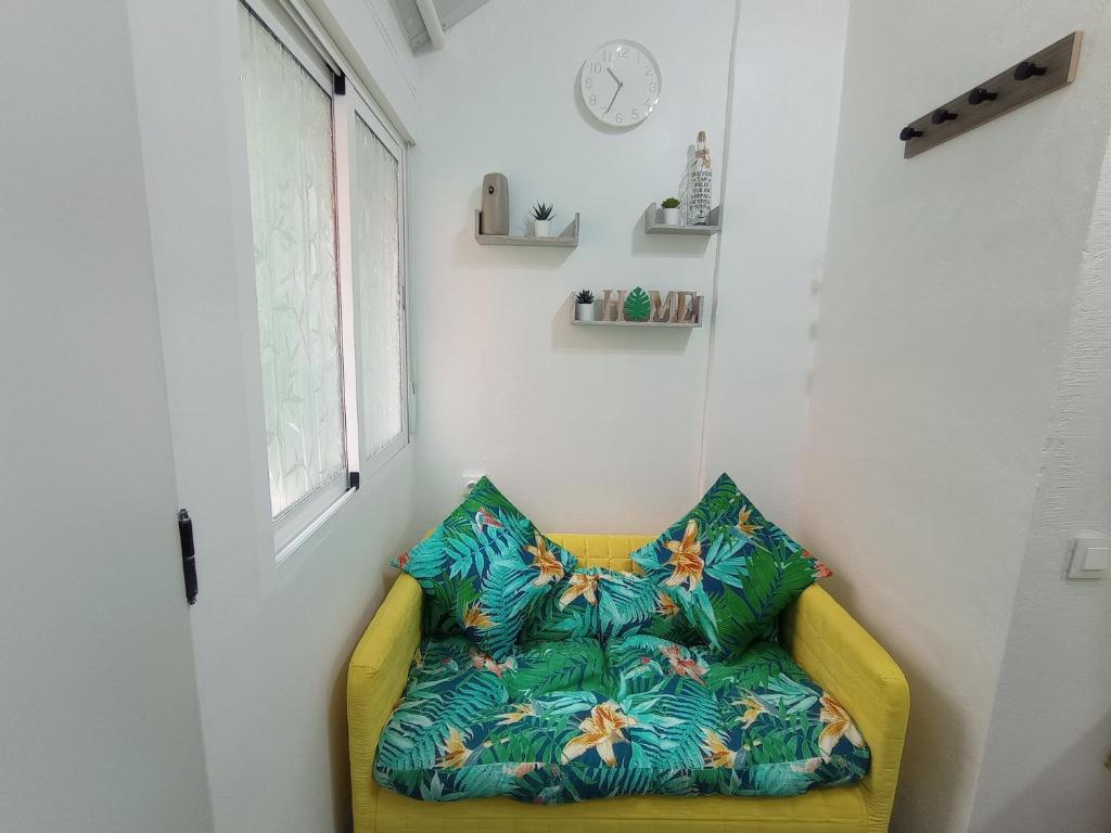 um sofá amarelo num quarto com uma janela em Green-Loft em Tacoronte