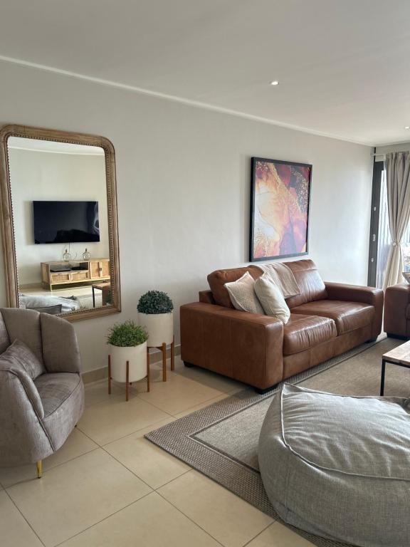 a living room with a couch and a mirror at The Pier 27 in Swakopmund