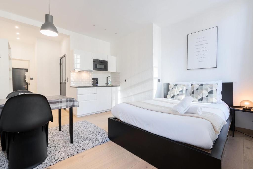 une chambre avec un lit et un bureau avec une chaise dans l'établissement Superbe appartement sur la Grand Place, avec vue !, à Lille