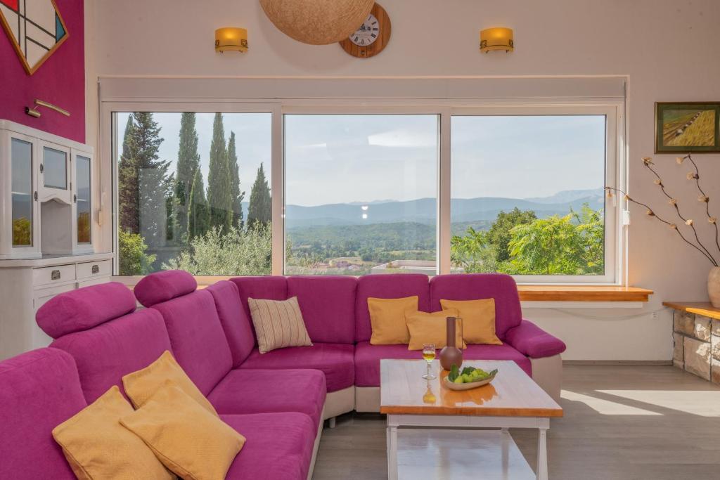 a purple couch in a living room with a large window at Villa Vita Croatica in Imotski