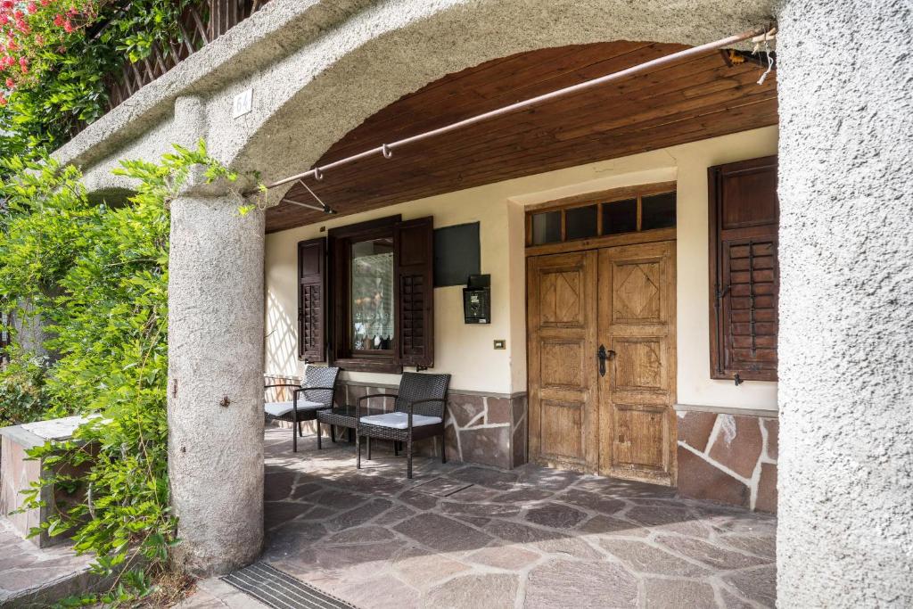 uma entrada para uma casa com uma porta de madeira em Casa Delmarco em Castello di Fiemme