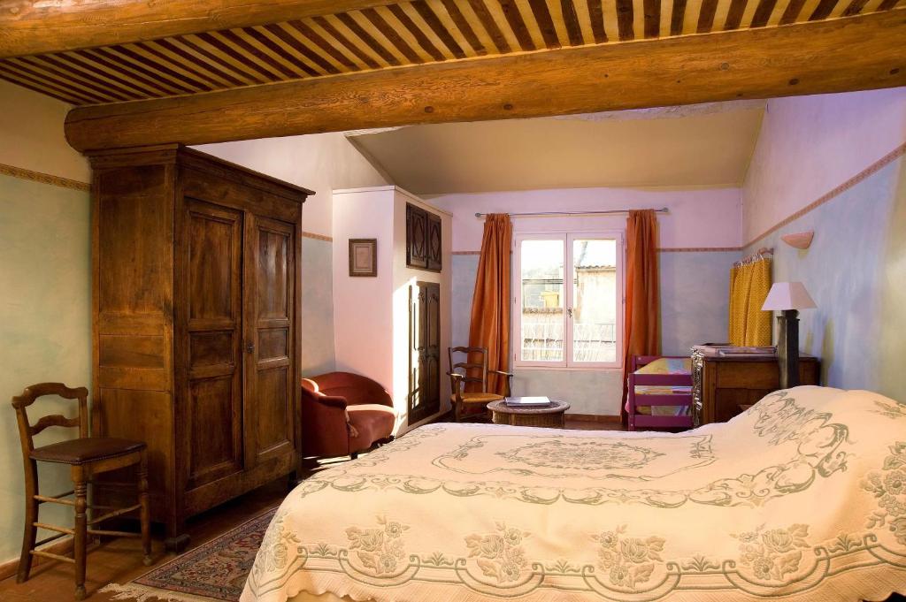 een slaapkamer met een groot bed in een kamer bij Auberge de la Fontaine in Rians