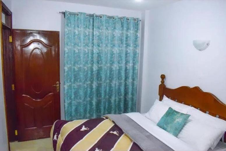 ein Schlafzimmer mit einem Bett mit einem blauen Vorhang in der Unterkunft One Bedroom BnB in Thika Town7 in Thika
