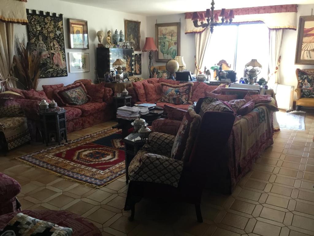 un soggiorno con divano rosso e sedie di Villa La Cerisaie a Céret