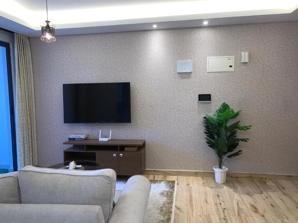 a living room with a couch and a tv on a wall at 1-BR Gem Near GTC, Westlands 5G in Nairobi