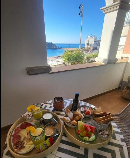a table with two plates of food on a table with a window at Casa Indiana Hotel Boutique in Blanes