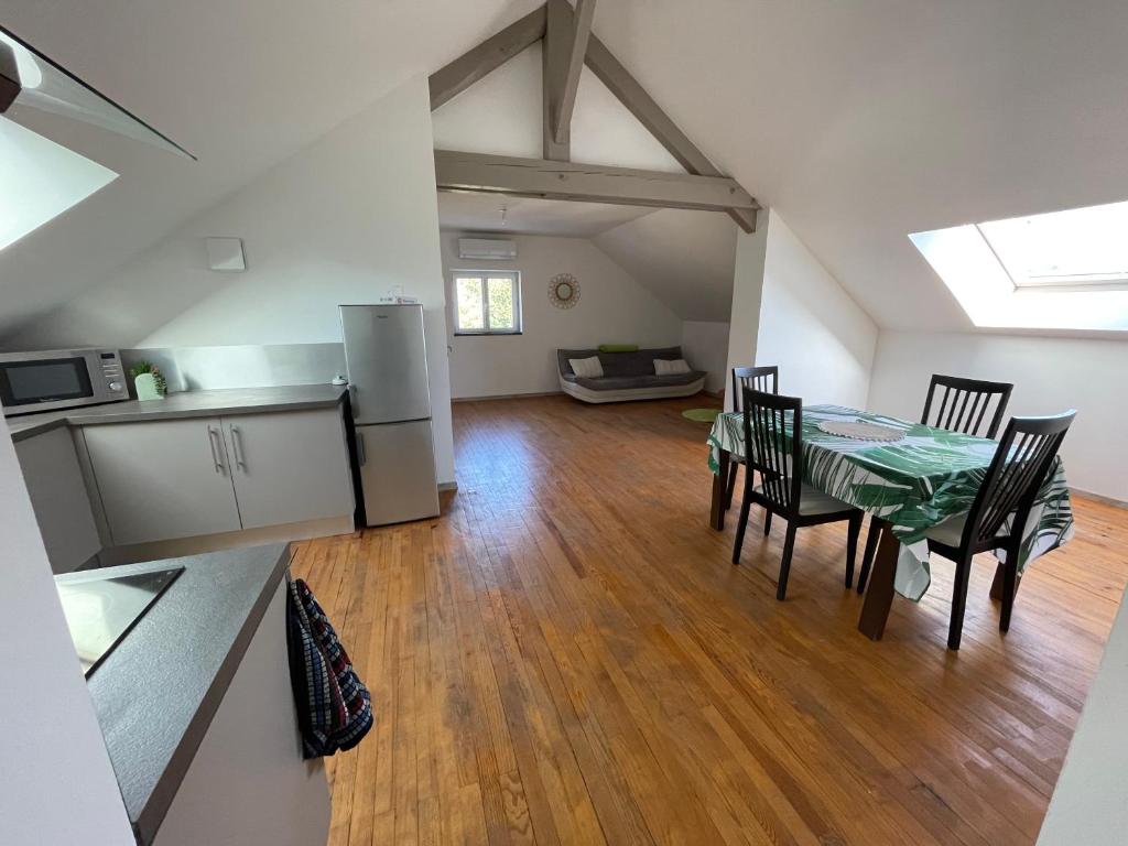 eine Küche und ein Esszimmer mit einem Tisch und Stühlen in der Unterkunft Appartement cosy in Massignieu-de-Rives