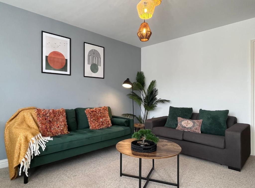 uma sala de estar com um sofá verde e uma mesa em Bright 1 bed central Worthing with sofa bed sleeps up to 4 close to beach by Eagle Owl Property em Worthing