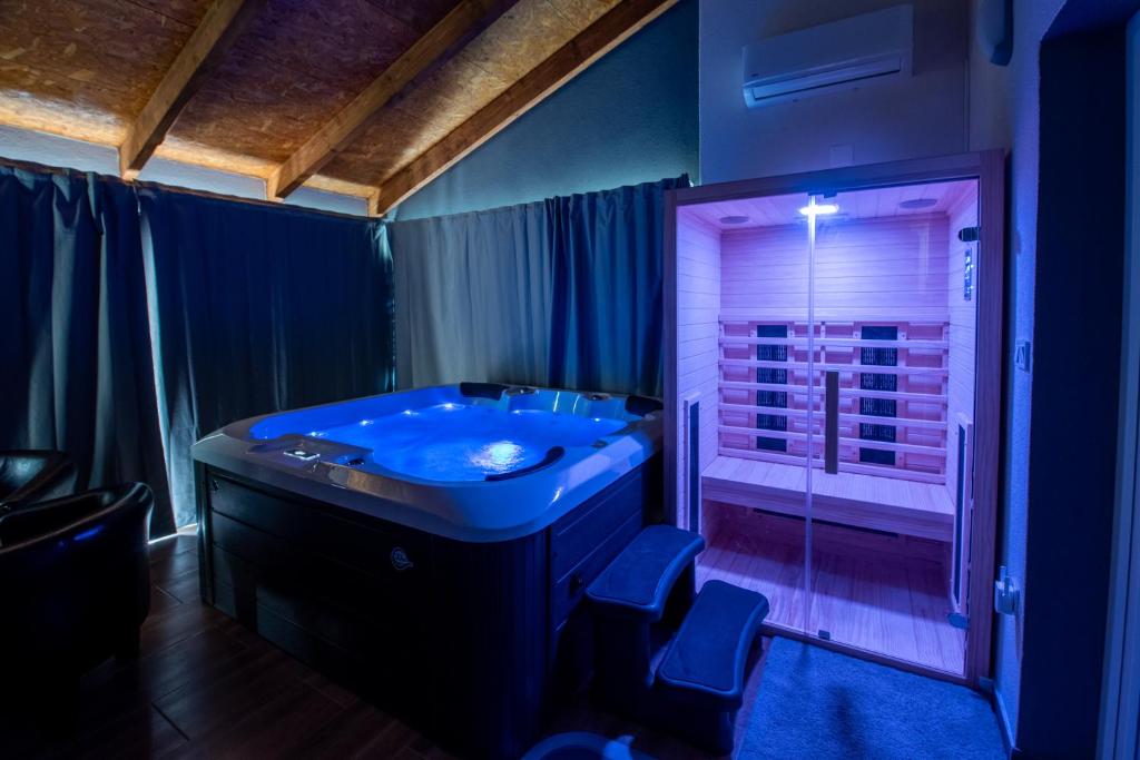 La salle de bains est pourvue d'une baignoire bleue et d'une douche. dans l'établissement Kuća dide Joze, à Velika